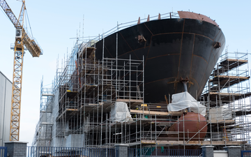 A large ship undergoing construction, surrounded by scaffolding