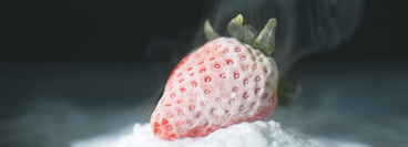 a strawberry that has been frozen and contains a frosting of ice